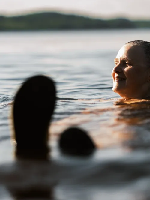Person som ligger i vatten och badar