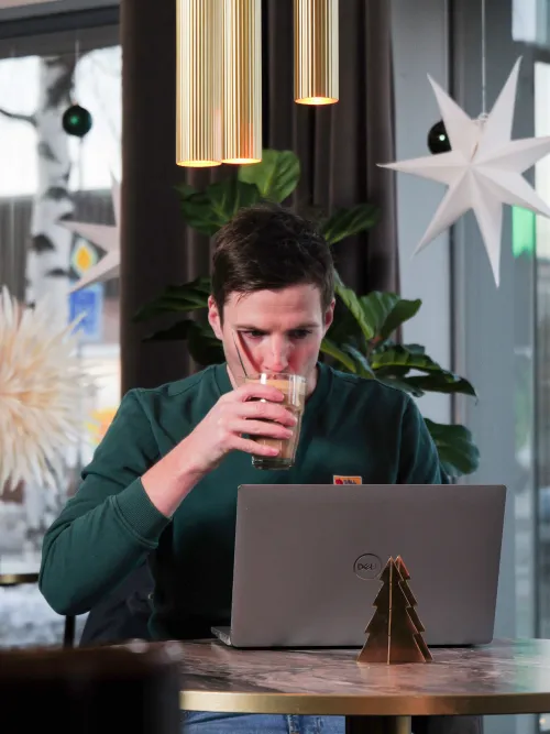 Person som sitter och arbetar på ett kafe