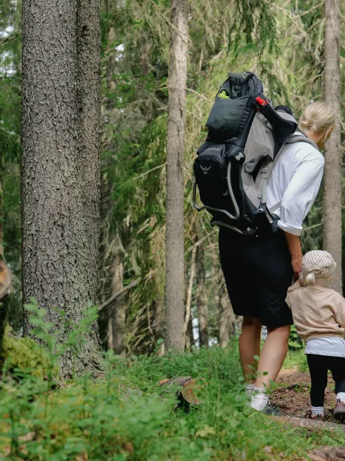 Mamma och barn vandrar i skogen