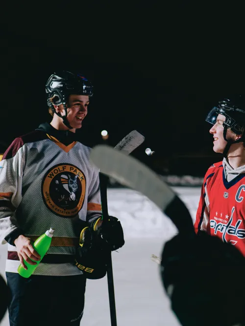 Grupp som står och pratar på isen i hockeyutrustning