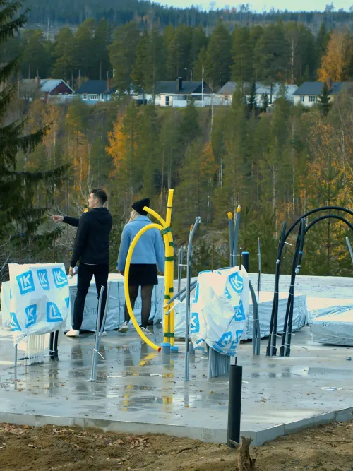Personer som står på en grunden till sitt framtida hus