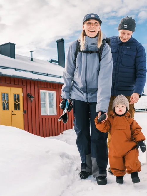 Familj som står framför sitt hus