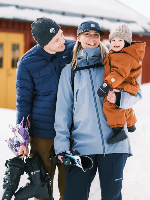Familj som står utanför sitt hus 