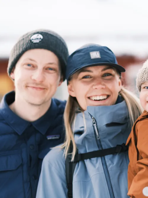 Familj som står utanför sitt hus 