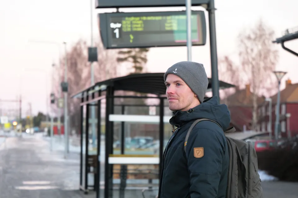 Man som står vid busshållplats