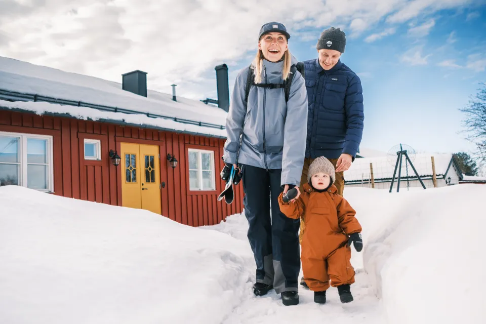 Familj som står framför sitt hus