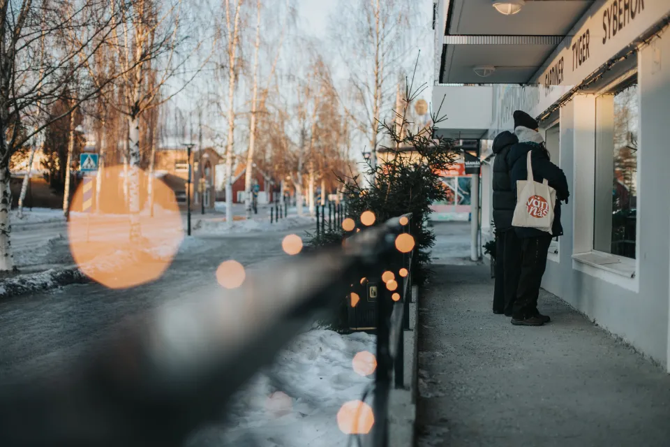 Personer som står och tittar in i skyltfönster i Vännäscentrum