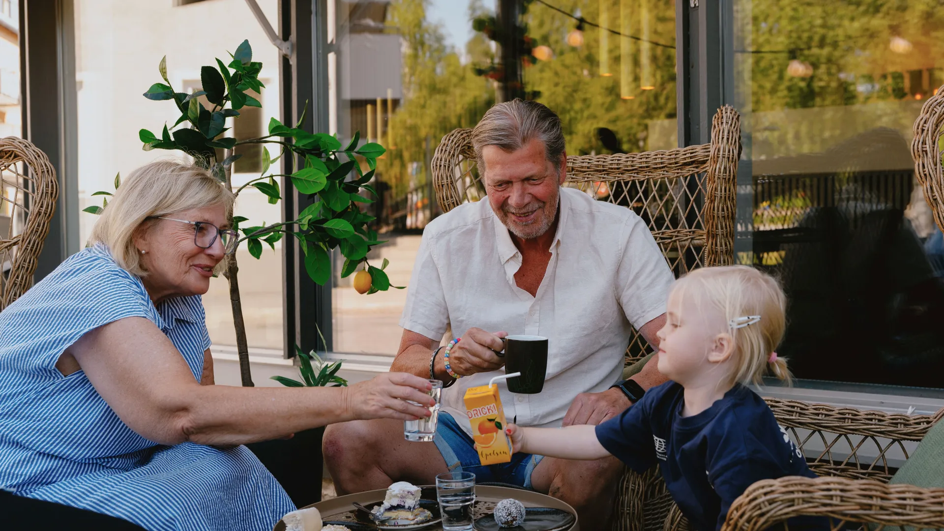 Familj som sitter på kafe och fikar