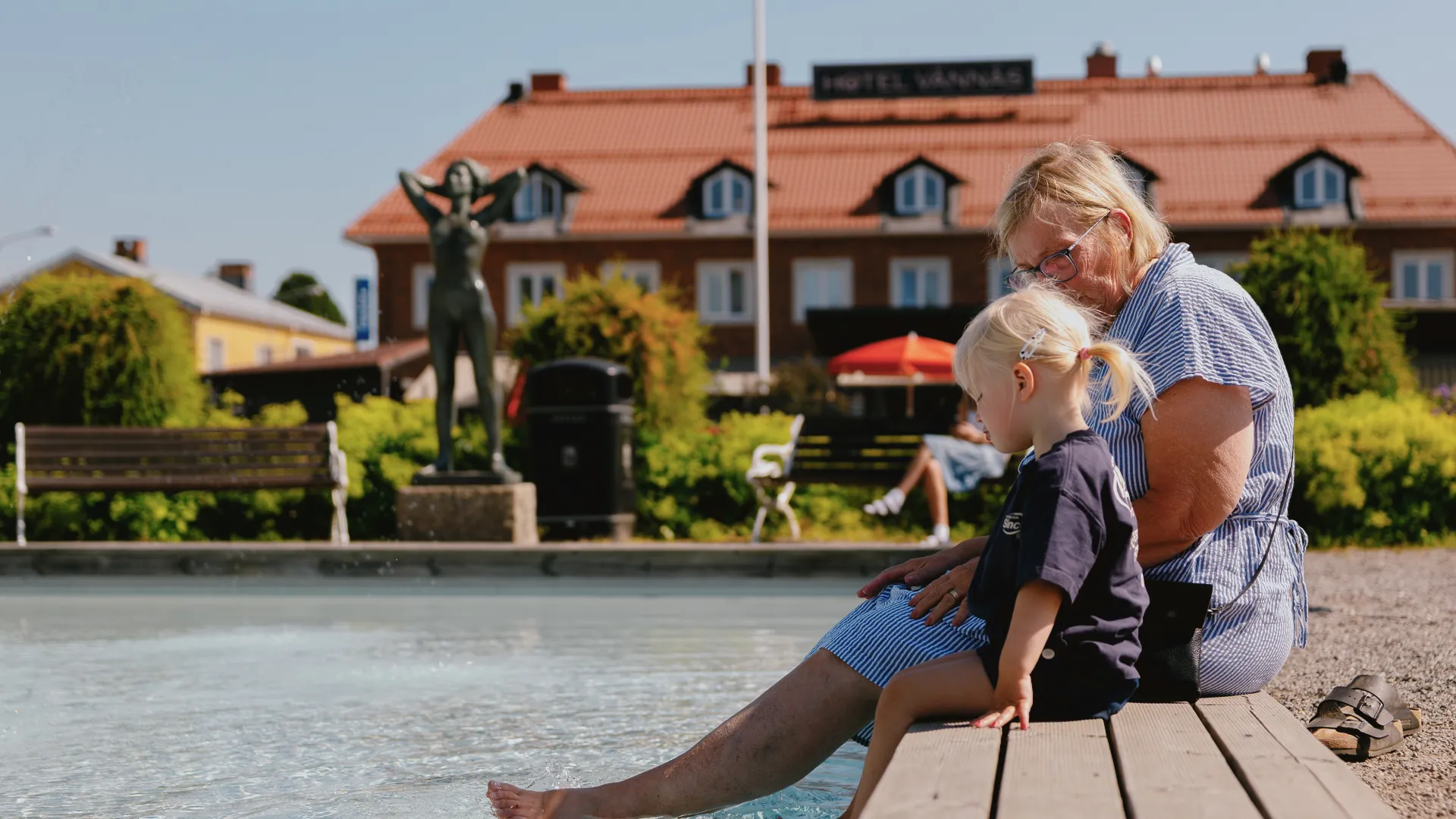 Två personer som badar fötterna i pool