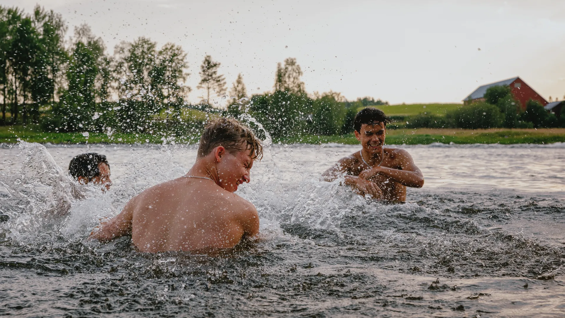 tre personer som badar i älven