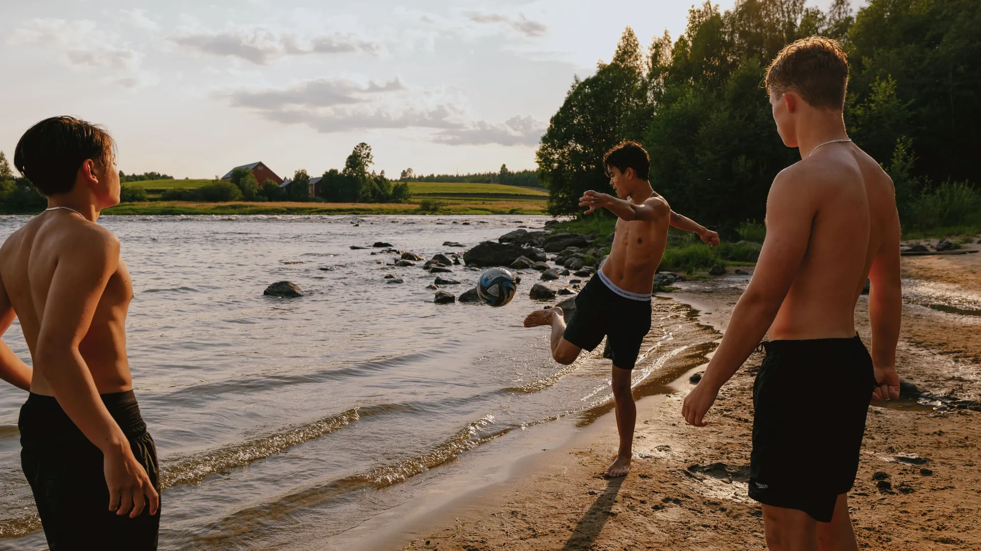 Ungdomar som som spelar fotboll på en strand